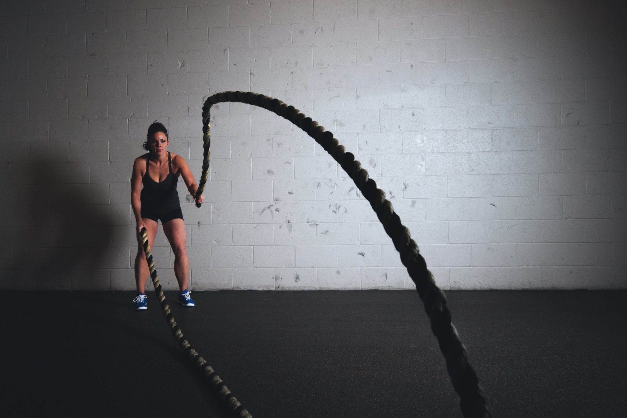Woman Training with Ropes at the Gym